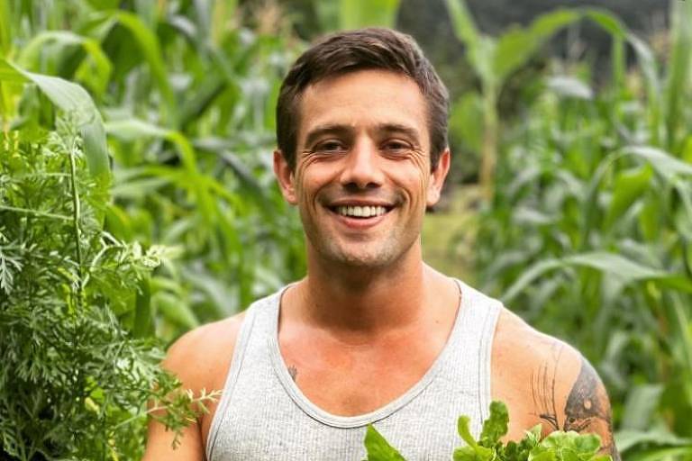 O ator Rafael Cardoso em foto postada em sua rede social. Ele veste uma regata cinza e é visto em meio a plantas em uma horta