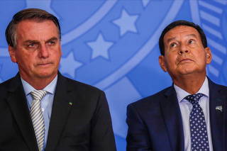 Brazil's President Jair Bolsonaro and Brazil's Vice President Hamilton Mourao react during a ceremony the Planalto Palace in Brasilia