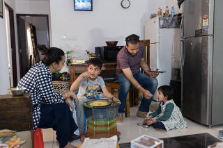 Akanksha Chadda and her husband, Ashish Anand, with their children, Rehan, 8, and Gunika, 4, at home in Noida, India, on March 31, 2021. (Smita Sharma/The New York Times)