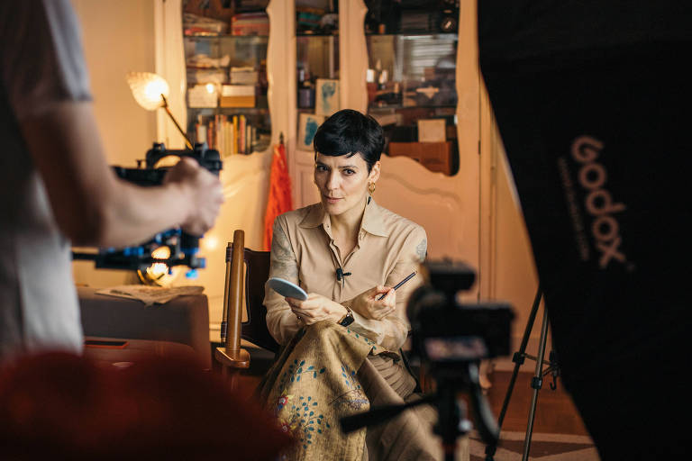 Vanessa Rozan sentada em frente a uma câmera, fazendo uma gravação
