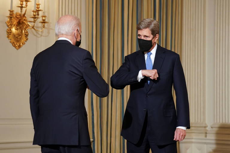 O enviado do governo americano para o clima, John Kerry, à dir., cumprimenta o presidente Joe Biden durante evento em Washington