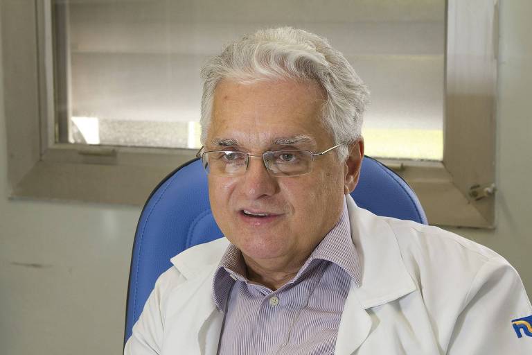 O epidemiologista Paulo Lotufo, professor de clínica médica da Faculdade de Medicina da USP, está sentado, de avental e óculos
