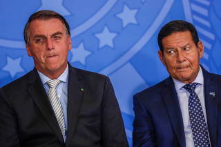 Brazil's President Jair Bolsonaro and Brazil's Vice President Hamilton Mourao react during a ceremony the Planalto Palace in Brasilia