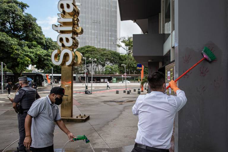 Funcionários limpam a fachada do Banco Safra na avenida Faria Lima, em São Paulo