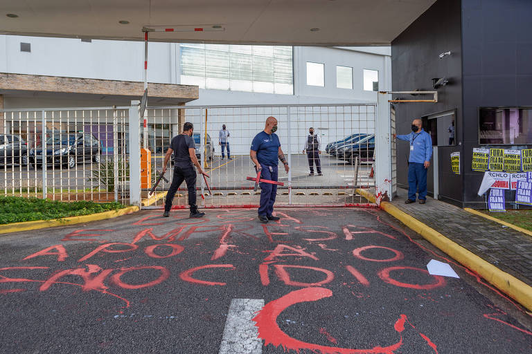 Manifestantes da Frente Povo Sem Medo pintam palavras de ordem da sede da Riachuelo, zona norte de São Paulo