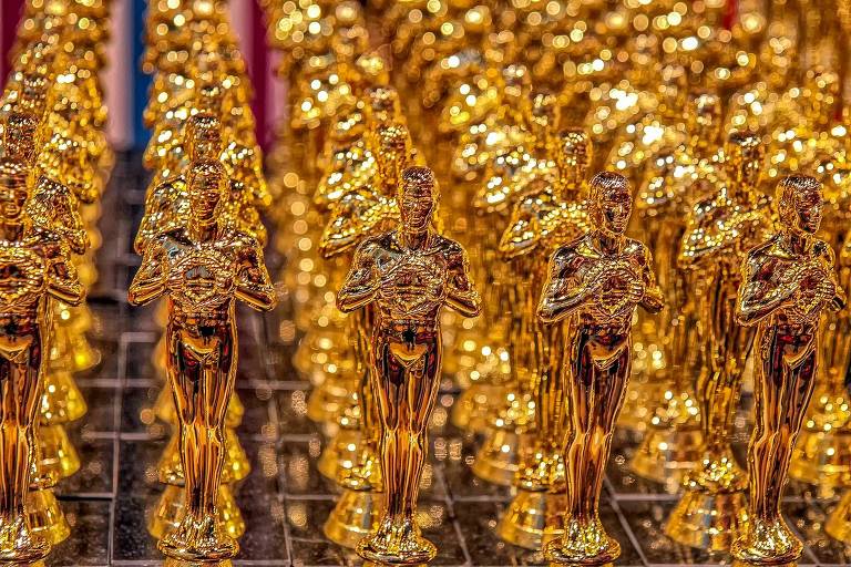 Diversas estatuetas douradas do Oscar, enfileiradas