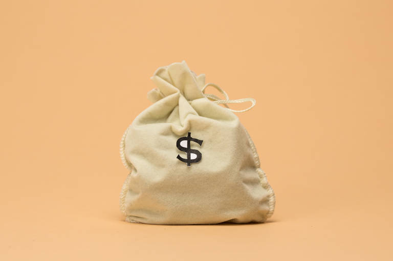 Foto mostra um fundo laranja claro com um saco de dinheiro bege com um cifrão preto desenhado