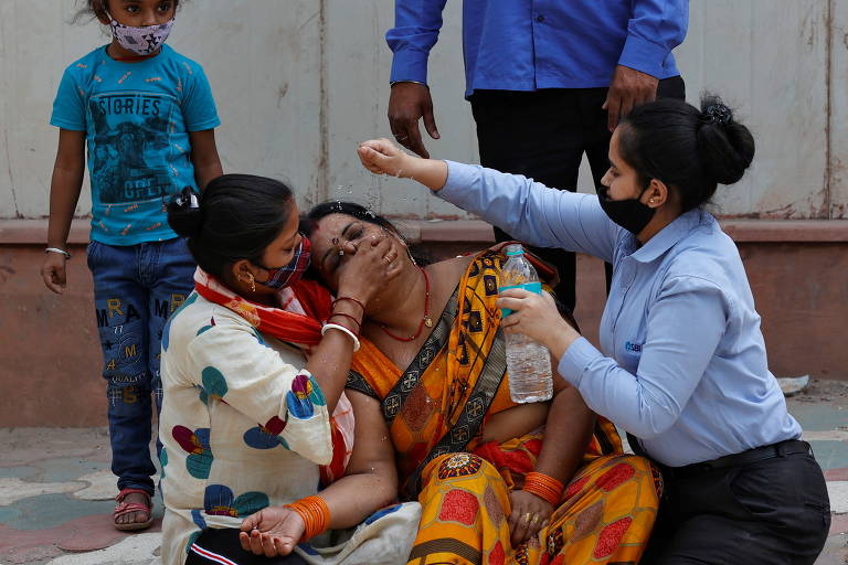 Mulher é consolada após a morte de seu marido por Covid-19 em Nova Déli, na Índia, país que detém o recorde mundial de casos da doença por dia