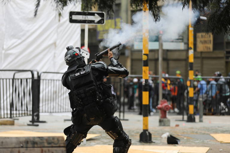 Policial dispara contra manifestantes durante protesto contra projeto de reforma tributária do presidente da Colômbia, Iván Duque, em Bogotá