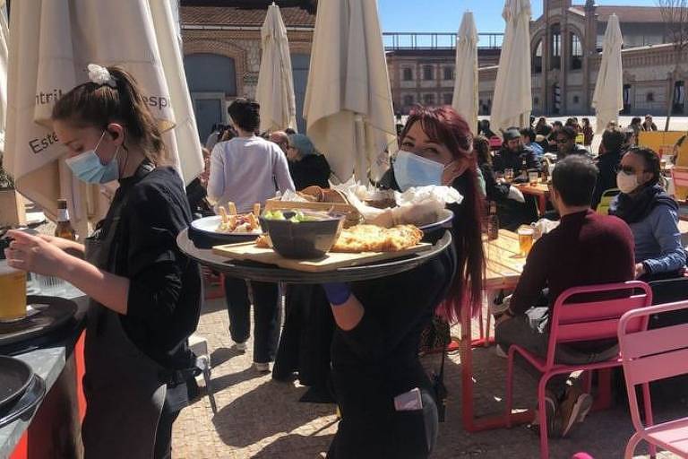 Pessoas se alimentam em mesas de restaurante ao ar livre