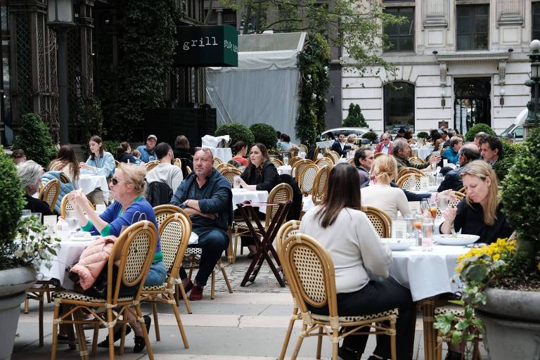 Pessoas fazem refeições em um restaurnte no Bryant Park, em Nova York; cidade se prepara para reabertura 