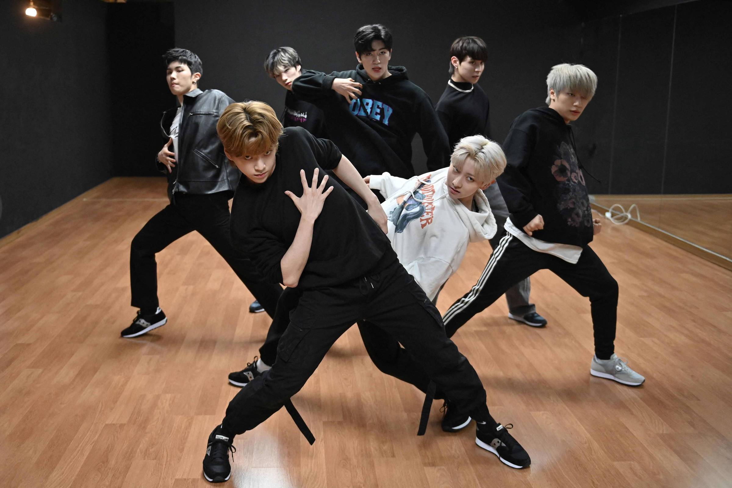 Grupos masculinos de k-pop coreanos estão no palco em uma pose