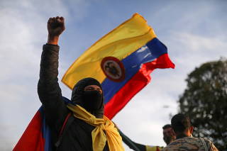 FILE PHOTO: A demonstrator takes part in a protest demanding government action to tackle poverty, police violence and inequalities in the health and education systems, in Bogota,