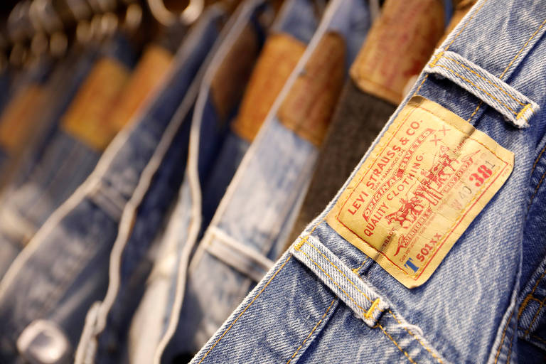 Várias calças jeans reunidas em varal de roupas