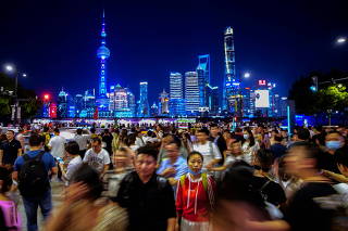 People walk along near the Bund, in front of Lujiazui financial district of Pudong, following the outbreak of the coronavirus disease (COVID-19), in Shanghai
