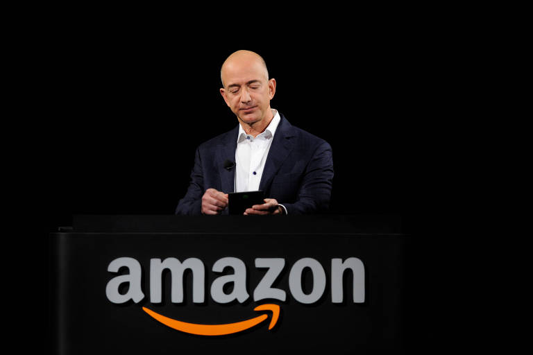 Imagem mostra Bezos em cima de um púlpito. É possível ver a logo da Amazon.