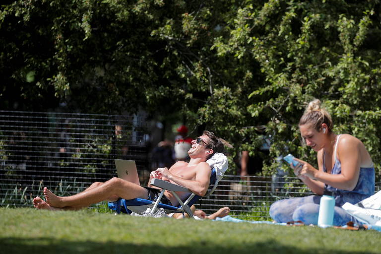Sem máscaras, pessoas tomam banho de sol no Washington Square Park, em Nova York