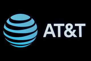 FILE PHOTO: The company logo for AT&T is displayed on a screen on the floor at the NYSE in New York