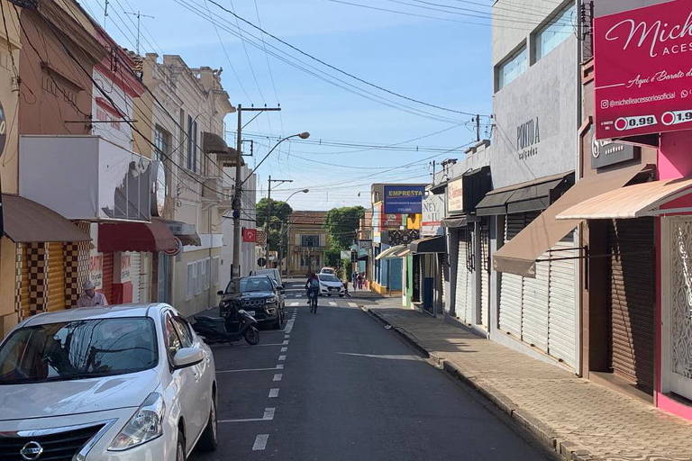 Imagem mostra lojas fechadas dos dois lados de rua no centro de Batatais. Ao fundo, o prédio da prefeitura