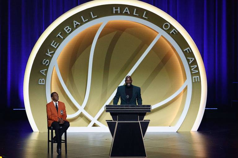 Kevin Garnett discursa, observado por Isiah Thomas, no dia de sua entrada para o Hall da Fama do basquete dos EUA
