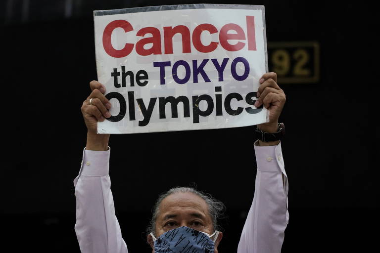 Manifestante protesta na capital japonesa com cartaz que diz "Cancelem a Olimpíada de Tóquio"