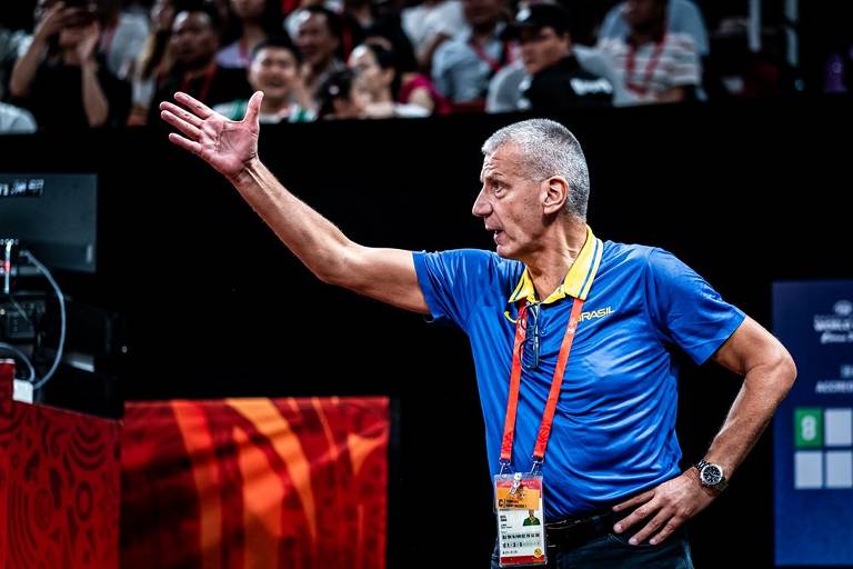 Técnico croata Aleksandar Petrovic, da seleção brasileira masculina de basquete, com uma mão na cintura e a outra gesticulando à beira da quadra