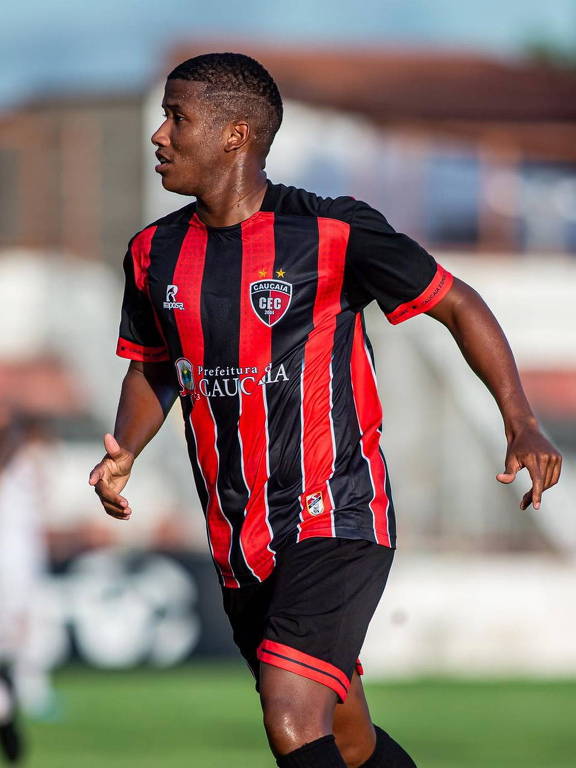 jogador de futebol negro com uniforme vermelho e preto do Caucaia Futebol Clube