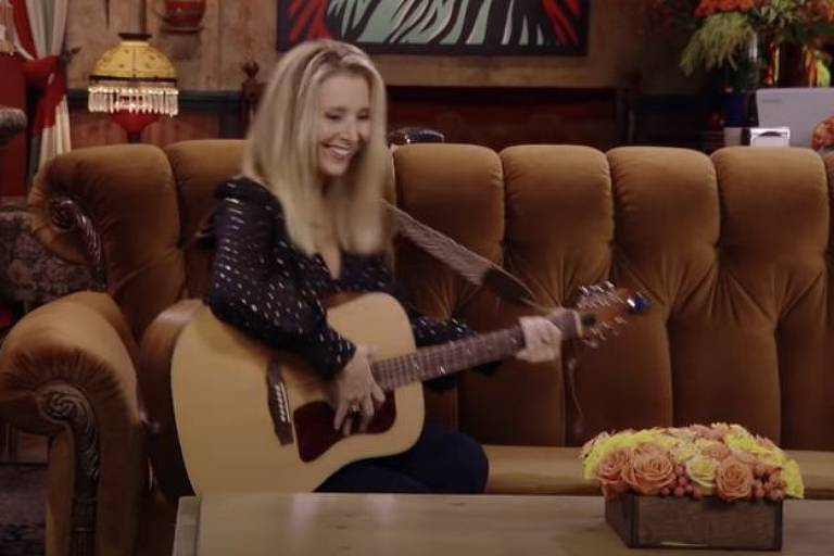 Lisa Kudrow com o famoso violão em que Phoebe Buffay tocava músicas com suas letras hilárias e por vezes constragendoras