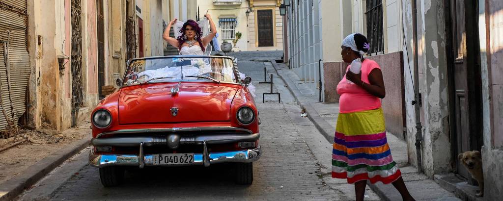 O ator do projeto 'Las Hermanas Algo', Alfredo de Armas, anda de carro conversível durante a execução de seu mais recente esquete sobre casamento igualitário em Havana, em 10 de maio de 2021
