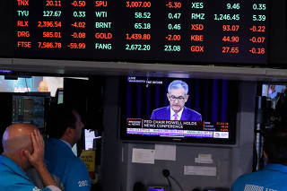 FILE PHOTO: FILE PHOTO: Traders look on as a screen shows Federal Reserve Chairman Jerome Powell's news conference after the U.S. Federal Reserve interest rates announcement on the floor of the New York Stock Exchange (NYSE) in New York
