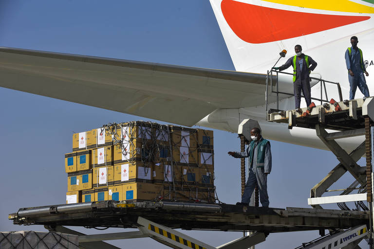 Funcionários de aeroporto de Adis Abeba desembarcam vacinas da farmacêutica Sinopharm doadas pelo governo chinês para a Etiópia