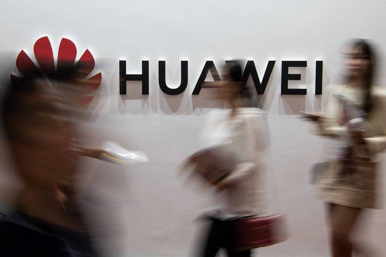Logo da Huawei com pessoas borradas passando em frente