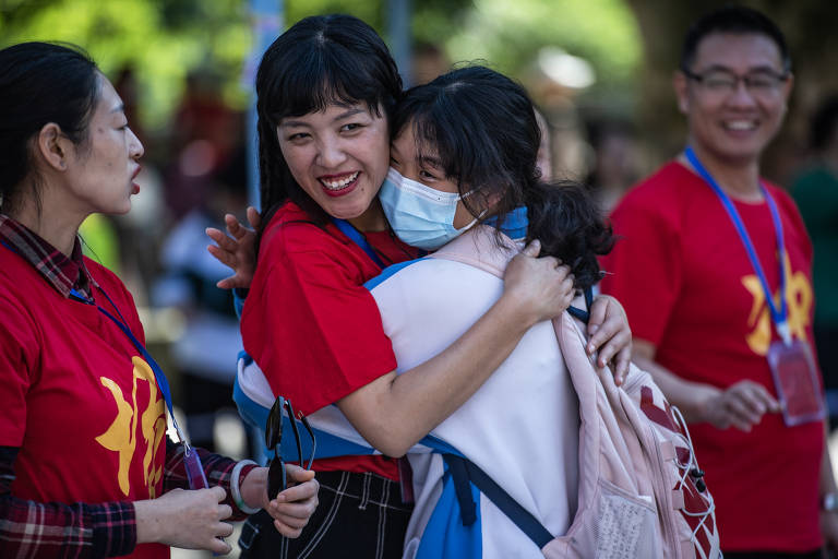 Uma candidata ao gaokao abraça sua professora em uma escola de ensino médio na cidade de Guiyang, na China, um dos locais onde estudantes podem fazer prova