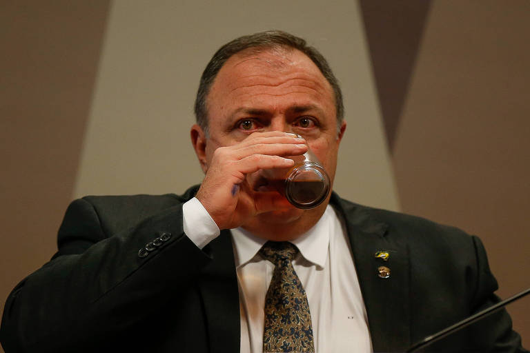 O ex-ministro da Saúde Eduardo Pazuello consome uma bebida durante depoimento à CPI que investiga a pandemia de Covid no Brasil