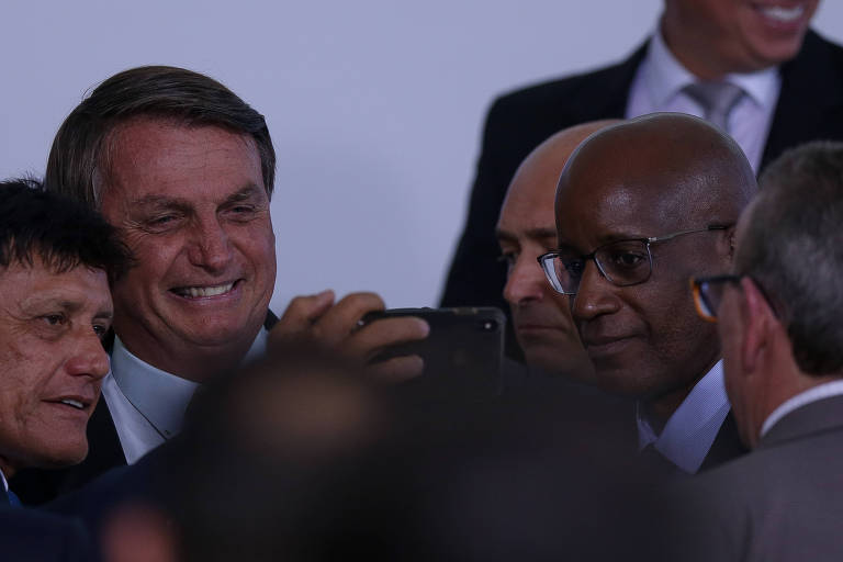O presidente Jair Bolsonaro, ao lado do presidente da Fundação Palmares Sérgio Camargo (à direita, de óculos), durante evento sobre a retomada do Turismo, no Palácio do Planalto, em novevmbro de 2020