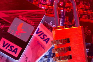 Visa credit cards and a padlock on a computer motherboard