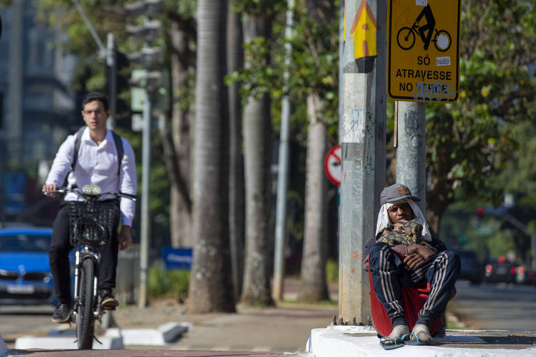 Ciclista passa ao lado de homem negro na ciclovia da Faria Lima; SP é o segundo estado mais desigual do país