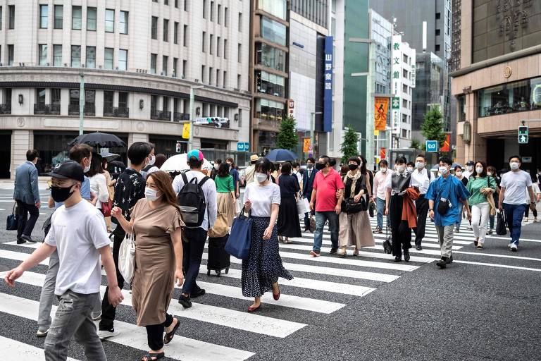 População circula pelas ruas de Tóquio com máscaras por causa da pandemia