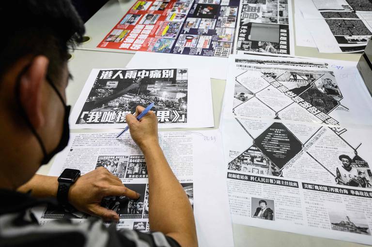 Funcionário do jornal Apple Daily revisa última edição impressa do tablóide publicado em Hong Kong