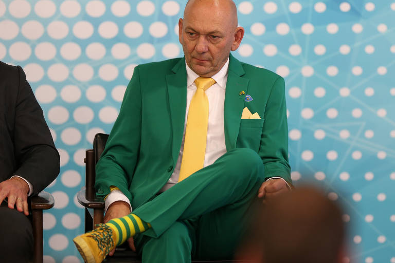 Homem com terno verde e gravata amarela