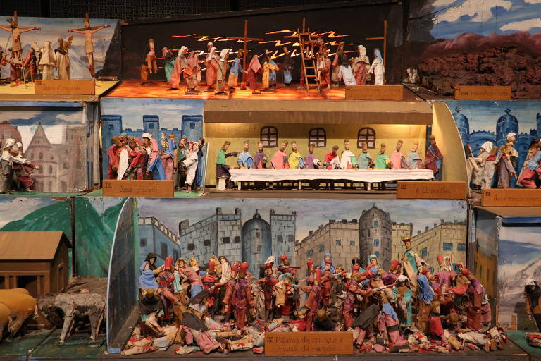 Obra sobre fases da vida de cristo feita com bonecos de madeira coloridos