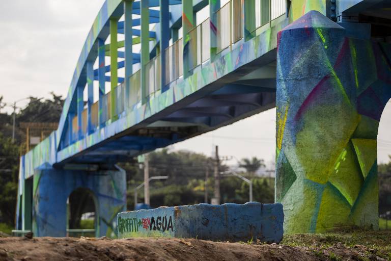 Ponte com pilares cilíndricos, pintada com grafite nas cores verde e azul