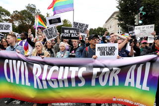 FILE PHOTO: FILE PHOTO: LGBTQ activists and supporters block the street outside the U.S. Supreme Court as it hears arguments in a major LGBT rights case in Washington