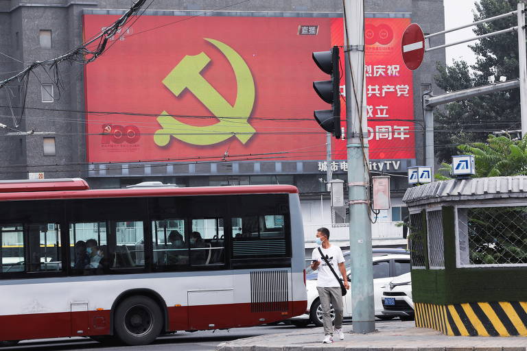 Telão na rua, em Pequim, transmite evento de entrega de medalhas que integra celebrações do centenário