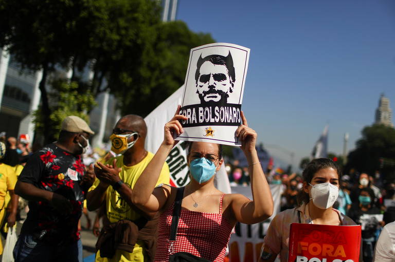 Mulher segura cartaz pedindo o impeachment de Bolsonaro em protesto no Rio