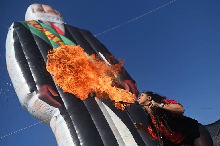 Mulher cospe fogo em frente a boneco inflável de Lula em protesto no Rio