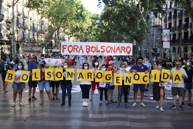 Manifestantes protestam com cartazes contra Bolsonaro nas Ramblas, ponto turístico de Barcelona, na Espanha