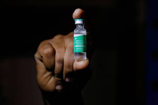 FILE PHOTO: A man displays a vial AstraZeneca's COVISHIELD vaccine as the country receives its first batch of coronavirus disease (COVID-19) vaccines under COVAX scheme, in Accra