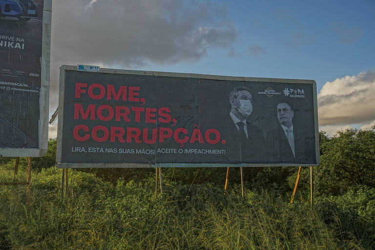 Outdoor como imagem de Athur Lira e Bolsonaro ao lado das palavras fome, mortes e corrupção