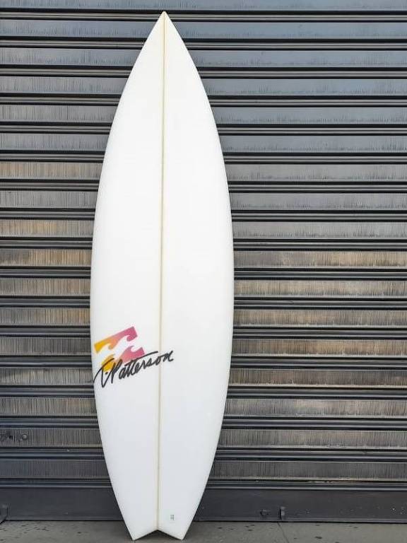 Prancha de surfe branca encostada na parede